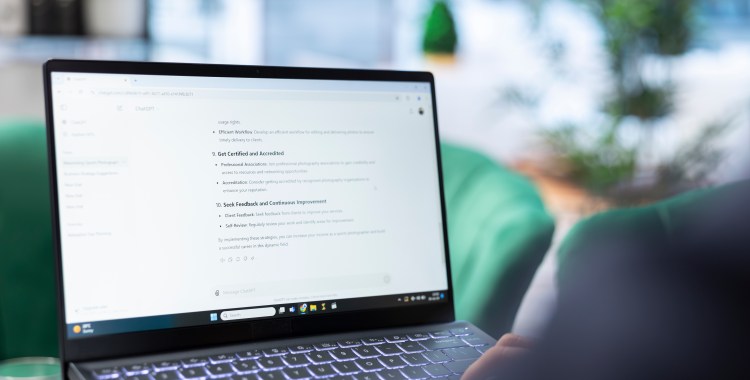 Profesional escribiendo una consulta a un chatbot de IA en su ordenador