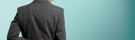Hombre de traje con los dedos cruzados a la espalda